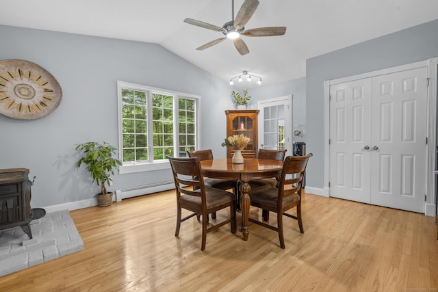 477 Skyline Dr, Orange, CT 06477 - dining area with a baseboard radiator, a wood stove, a ceiling fan, vaulted ceiling, and light wood-type flooring