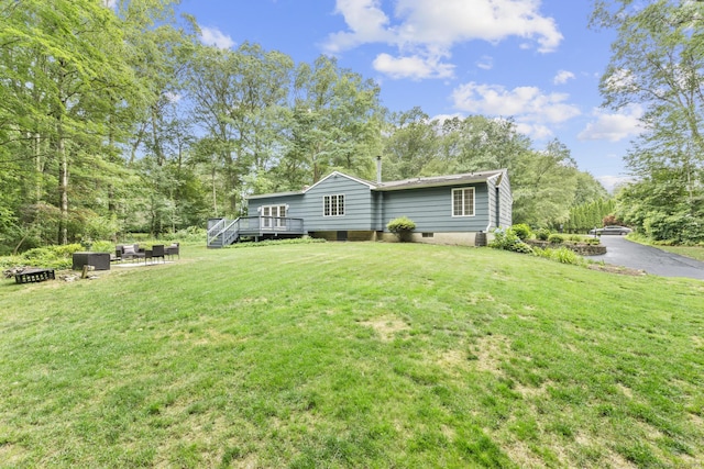477 Skyline Dr, Orange, CT 06477 - view of front of property with a deck, a front yard, an outdoor fire pit, and view of scattered trees