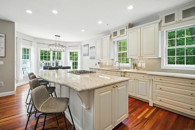 31 Galbraith Rd, Stafford, CT 06071 - kitchen with plenty of natural light, a kitchen island, a kitchen bar, glass insert cabinets, and recessed lighting