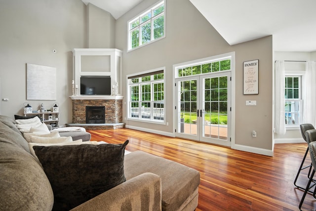 31 Galbraith Rd, Stafford, CT 06071 - living room featuring wood finished floors, a stone fireplace, high vaulted ceiling, and french doors