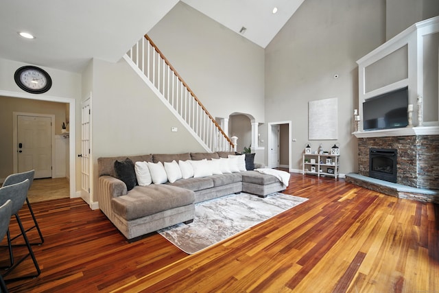 31 Galbraith Rd, Stafford, CT 06071 - living area featuring hardwood / wood-style flooring, arched walkways, high vaulted ceiling, a stone fireplace, and stairway