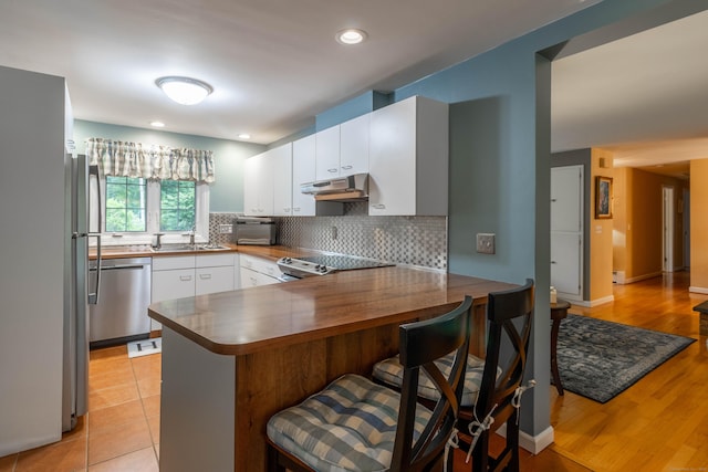 4 Melburn Ave, East Hampton, CT 06424 - kitchen with a peninsula, dishwasher, white cabinetry, decorative backsplash, and a breakfast bar