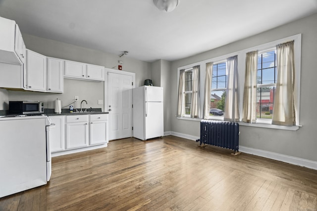 1492 Dixwell Ave, Hamden, CT 06514 - kitchen featuring radiator heating unit, freestanding refrigerator, stove, stainless steel microwave, and white cabinets