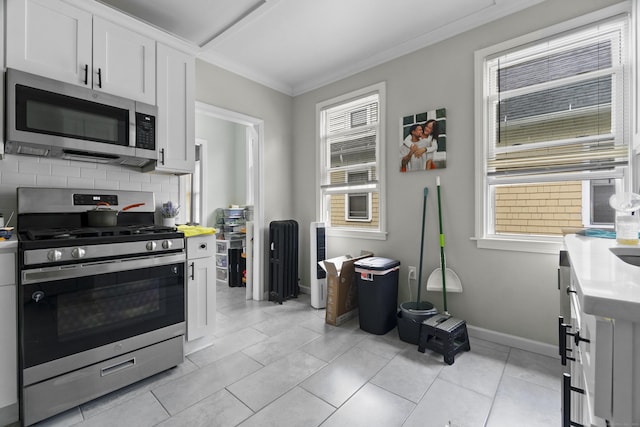 1492 Dixwell Ave, Hamden, CT 06514 - kitchen with stainless steel appliances, light countertops, backsplash, healthy amount of natural light, and crown molding