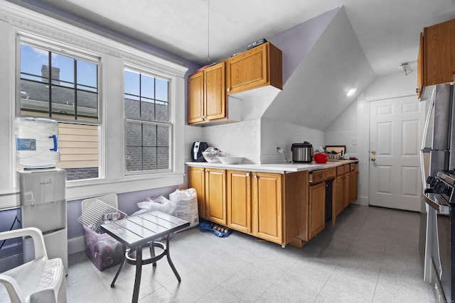 1492 Dixwell Ave, Hamden, CT 06514 - kitchen with stove, light countertops, brown cabinets, freestanding refrigerator, and vaulted ceiling