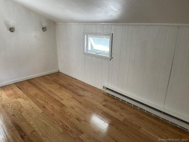 236 Mistuxet Ave, Stonington, CT 06355 - spare room with a baseboard heating unit, wood finished floors, and wooden walls