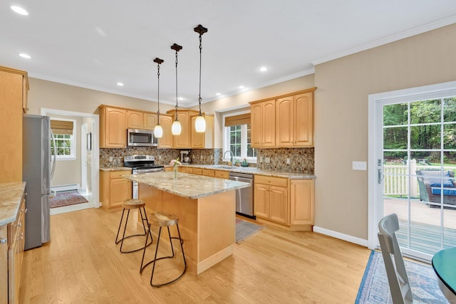 190 Charles St, Tolland, CT 06084 - kitchen with appliances with stainless steel finishes, light brown cabinetry, light wood-style floors, a kitchen island, and tasteful backsplash