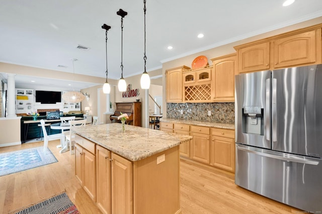 190 Charles St, Tolland, CT 06084 - kitchen featuring stainless steel refrigerator with ice dispenser, light wood finished floors, a kitchen island, a fireplace, and light stone counters