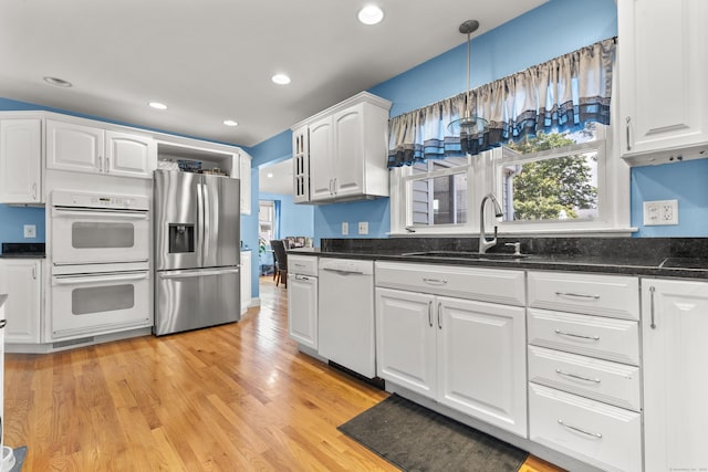 107 May St, West Haven, CT 06516 - kitchen with white appliances, white cabinets, light wood-style floors, dark stone counters, and recessed lighting
