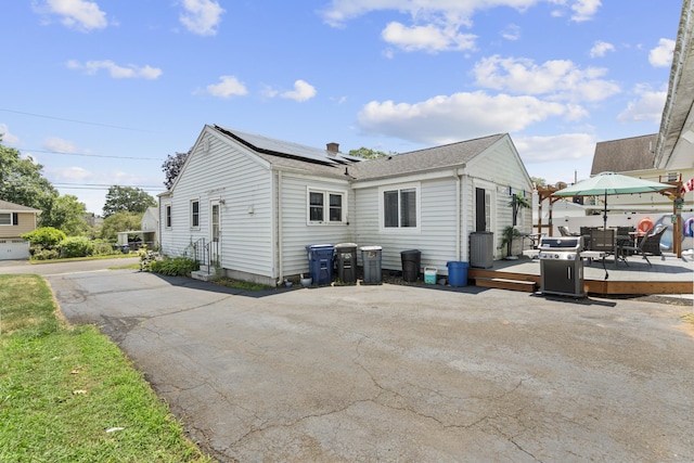 107 May St, West Haven, CT 06516 - back of house with a wooden deck, roof mounted solar panels, and roof with shingles
