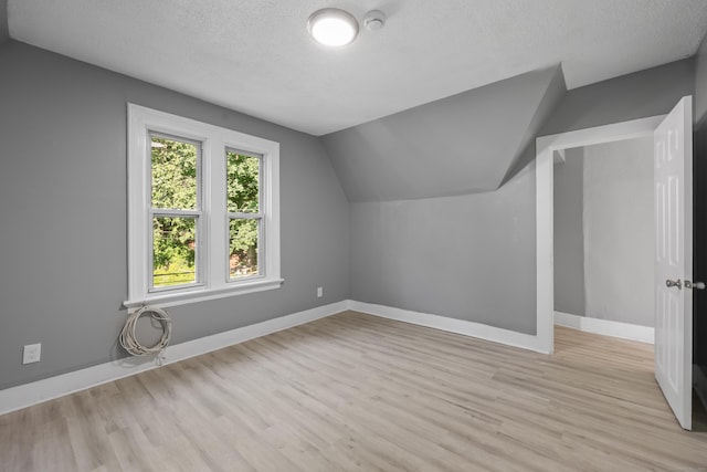 122 Oak St, Naugatuck, CT 06770 - bonus room featuring light wood-style flooring, vaulted ceiling, and a textured ceiling