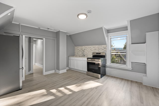 122 Oak St, Naugatuck, CT 06770 - kitchen with stainless steel appliances, light wood-style floors, light countertops, white cabinetry, and lofted ceiling
