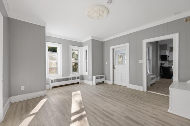 122 Oak St, Naugatuck, CT 06770 - entryway featuring radiator heating unit, light wood-style flooring, and ornamental molding