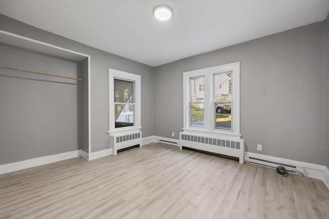 122 Oak St, Naugatuck, CT 06770 - unfurnished bedroom featuring radiator, multiple windows, and wood finished floors