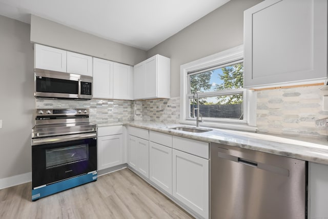 122 Oak St, Naugatuck, CT 06770 - kitchen with stainless steel appliances, light stone counters, light wood-style flooring, and white cabinets