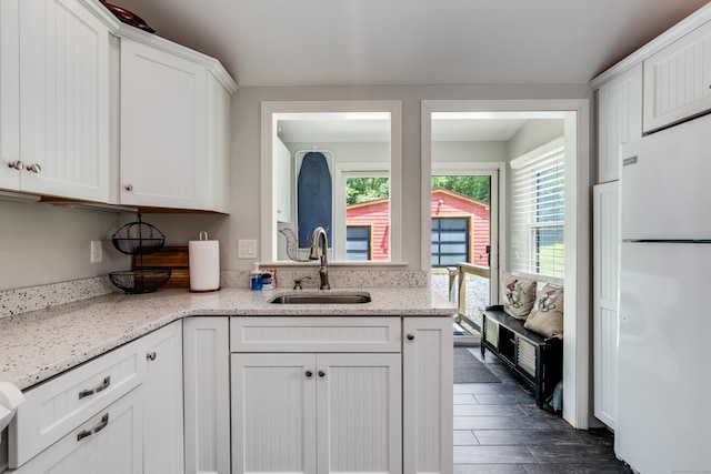 114 Lakeside Dr, East Haddam, CT 06423 - kitchen with freestanding refrigerator, white cabinets, and light stone countertops