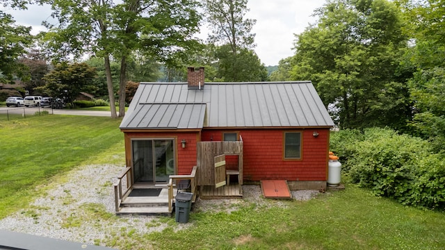 114 Lakeside Dr, East Haddam, CT 06423 - rear view of house with a standing seam roof, a chimney, a yard, a metal roof, and view of wooded area
