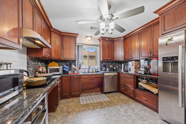 87 Kaynor Dr, Waterbury, CT 06708 - kitchen with stainless steel appliances, under cabinet range hood, a ceiling fan, tasteful backsplash, and dark stone countertops