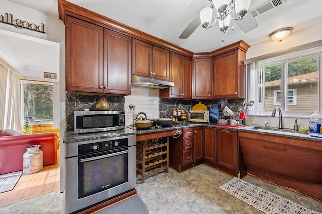 87 Kaynor Dr, Waterbury, CT 06708 - kitchen with appliances with stainless steel finishes, ceiling fan, tasteful backsplash, under cabinet range hood, and dark stone countertops