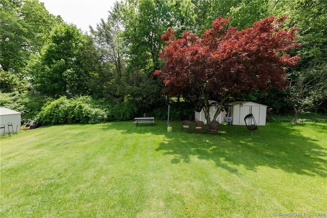 87 Kaynor Dr, Waterbury, CT 06708 - view of grassy yard with a storage unit and view of wooded area