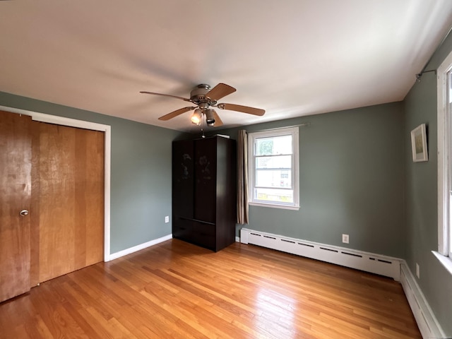 2 Wentworth Dr, Milford, CT 06460 - unfurnished bedroom with wood finished floors, baseboard heating, a ceiling fan, and a closet