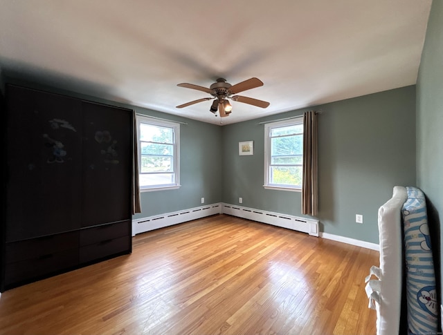 2 Wentworth Dr, Milford, CT 06460 - unfurnished bedroom with multiple windows, light wood-style flooring, and a baseboard radiator
