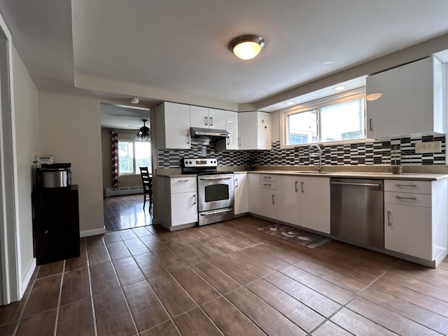 2 Wentworth Dr, Milford, CT 06460 - kitchen with stainless steel appliances, a baseboard radiator, under cabinet range hood, and decorative backsplash