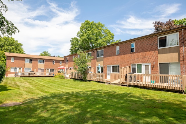 275 Pierremount Ave Unit 275, New Britain, CT 06053 - back of property with brick siding, a lawn, and a deck