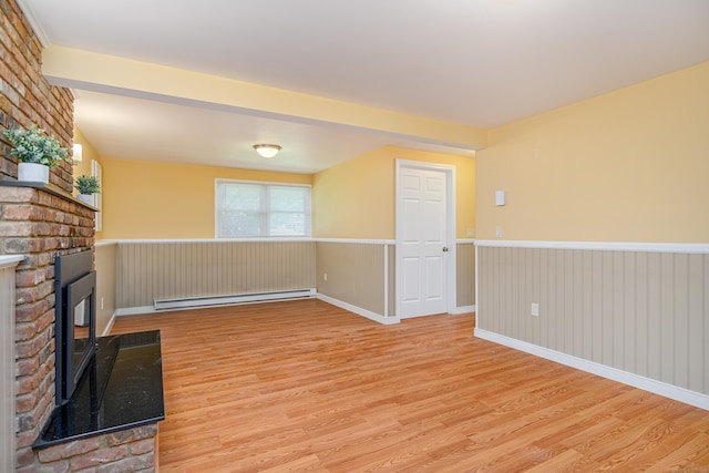 15 Sky Edge Ln, Bethel, CT 06801 - unfurnished living room with baseboard heating, wood finished floors, a fireplace, and wainscoting
