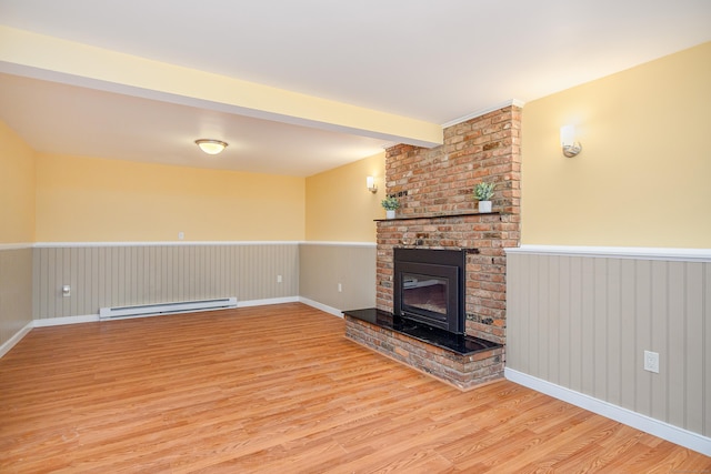 15 Sky Edge Ln, Bethel, CT 06801 - unfurnished living room with baseboard heating, light wood-type flooring, wainscoting, and a brick fireplace