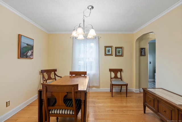 35 Grandview Ter, Wethersfield, CT 06109 - dining space with arched walkways, a chandelier, ornamental molding, light wood-style floors, and a textured ceiling