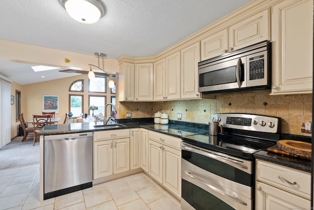 35 Grandview Ter, Wethersfield, CT 06109 - kitchen with cream cabinets, appliances with stainless steel finishes, a skylight, a peninsula, and backsplash