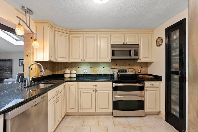 35 Grandview Ter, Wethersfield, CT 06109 - kitchen featuring cream cabinetry, stainless steel appliances, a skylight, decorative backsplash, and a textured ceiling