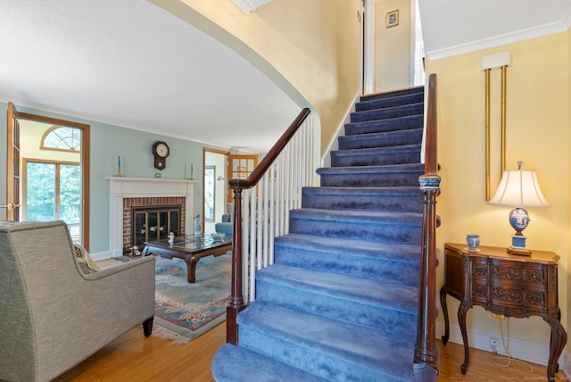 35 Grandview Ter, Wethersfield, CT 06109 - stairway with wood finished floors, crown molding, a fireplace, and arched walkways