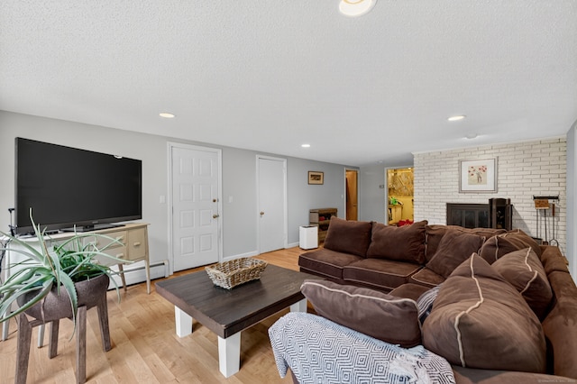3 Laurel Hill Dr S, East Lyme, CT 06357 - living area featuring a textured ceiling, light wood-style floors, a brick fireplace, baseboard heating, and recessed lighting