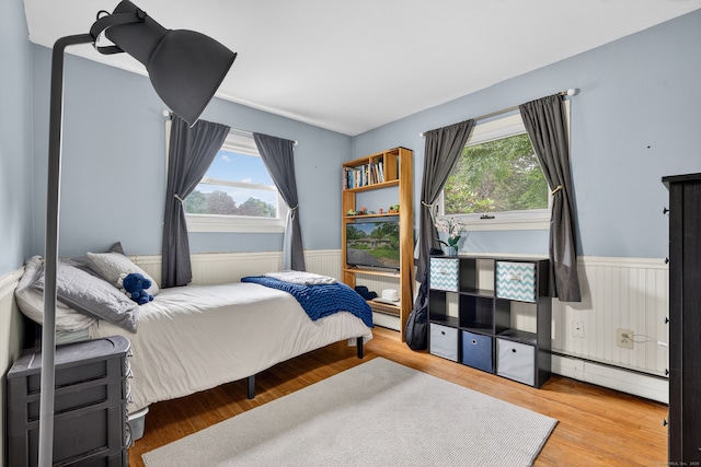 3 Laurel Hill Dr S, East Lyme, CT 06357 - bedroom featuring baseboard heating, wainscoting, multiple windows, and wood finished floors