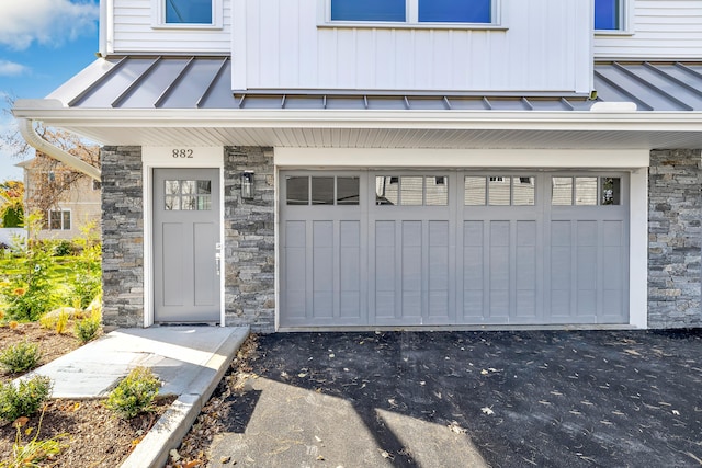 888 Oldfield Rd, Fairfield, CT 06824 - entrance to property featuring a standing seam roof, stone siding, an attached garage, and a metal roof