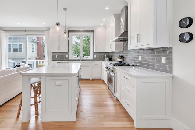 888 Oldfield Rd, Fairfield, CT 06824 - kitchen with wall chimney range hood, high end stainless steel range oven, a kitchen bar, light countertops, and recessed lighting