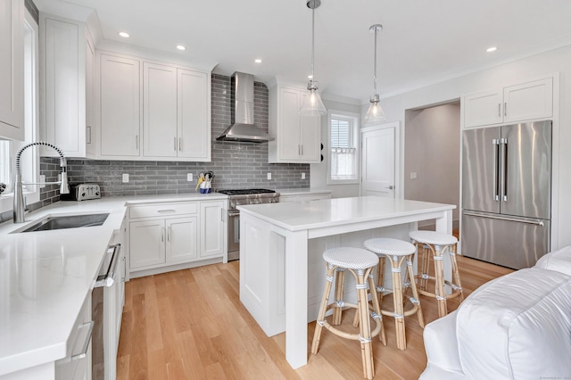 888 Oldfield Rd, Fairfield, CT 06824 - kitchen featuring high end appliances, wall chimney exhaust hood, light wood-type flooring, backsplash, and recessed lighting