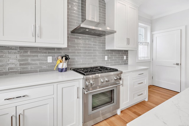 888 Oldfield Rd, Fairfield, CT 06824 - kitchen with high end stove, wall chimney range hood, white cabinetry, and decorative backsplash