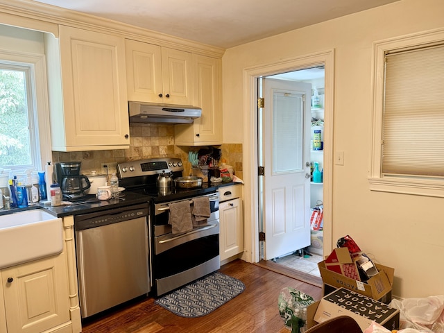 271 Jeniford Rd, Fairfield, CT 06824 - kitchen featuring appliances with stainless steel finishes, under cabinet range hood, dark countertops, tasteful backsplash, and dark wood-type flooring