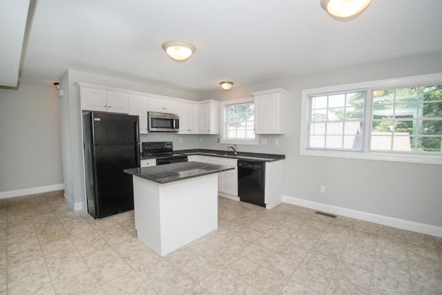 783 Naugatuck Ave, Milford, CT 06461 - kitchen featuring black appliances, white cabinetry, a kitchen island, and dark stone countertops