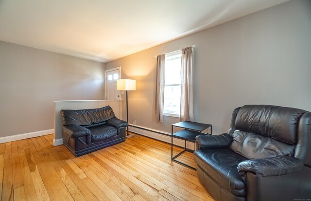 635 Ruth St, Bridgeport, CT 06606 - living area with light wood-type flooring and a baseboard heating unit