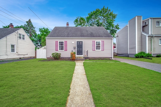 635 Ruth St, Bridgeport, CT 06606 - view of front facade featuring a front yard, a shingled roof, and a chimney