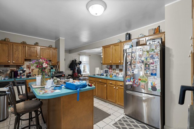 78 Church St, Hamden, CT 06514 - kitchen with freestanding refrigerator, brown cabinetry, and a kitchen island