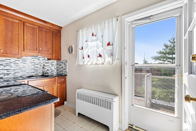 90 Strawberry Hill Ave Unit 3, Stamford, CT 06902 - kitchen featuring radiator, dark countertops, tasteful backsplash, and brown cabinetry