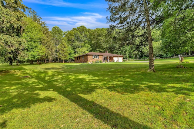 449 Mohegan Avenue Parkway, Waterford, CT 06375 - view of green lawn featuring a forest view and an attached garage