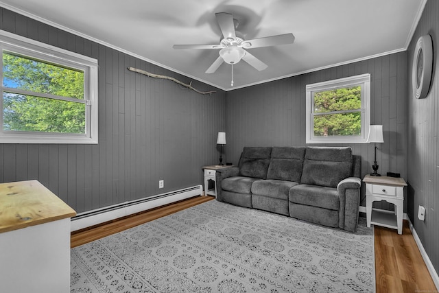 449 Mohegan Avenue Parkway, Waterford, CT 06375 - living area featuring baseboard heating, wood finished floors, ornamental molding, ceiling fan, and wooden walls