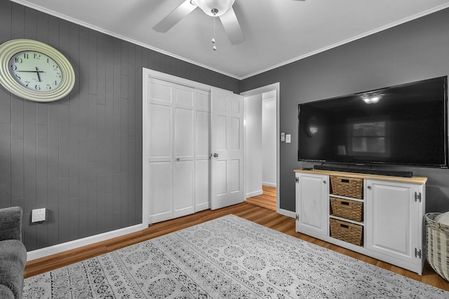 449 Mohegan Avenue Parkway, Waterford, CT 06375 - bedroom with wood finished floors, crown molding, ceiling fan, a closet, and wooden walls