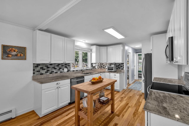 449 Mohegan Avenue Parkway, Waterford, CT 06375 - kitchen featuring appliances with stainless steel finishes, baseboard heating, light wood-style flooring, decorative backsplash, and white cabinets